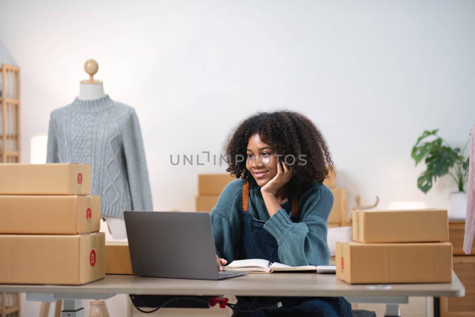 Young woman freelancer sme business online shopping look at camera with cardboard box on table at home - Business online shipping and delivery concept..