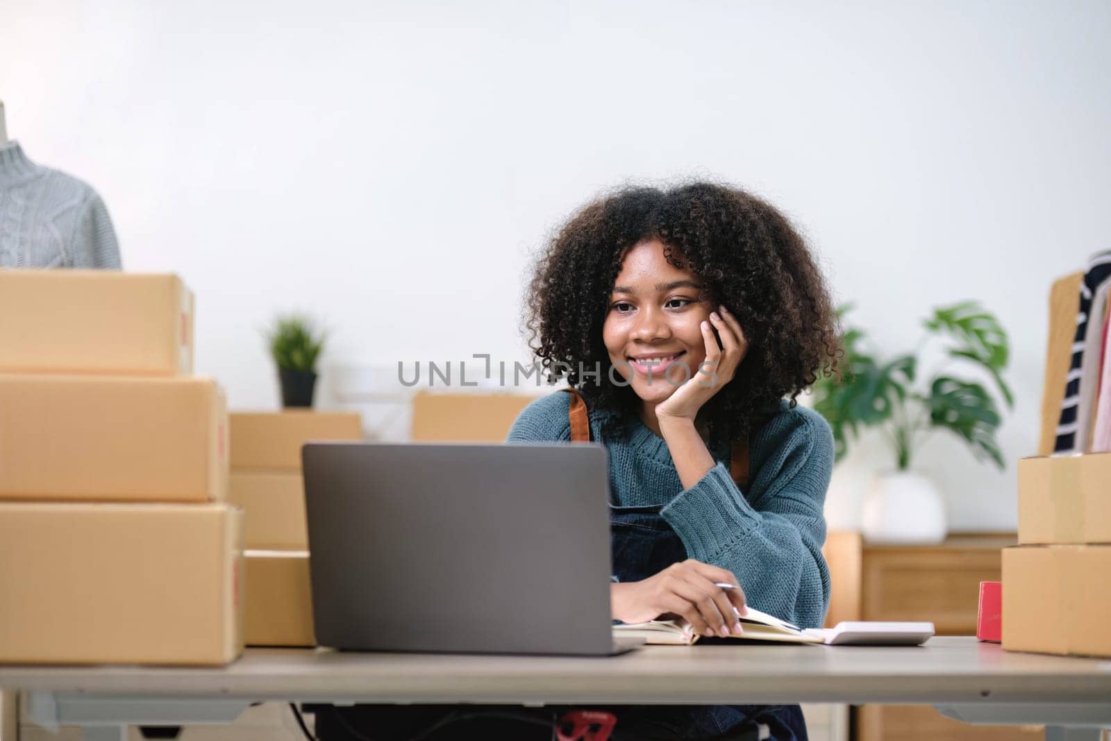 Young woman freelancer sme business online shopping look at camera with cardboard box on table at home - Business online shipping and delivery concept..