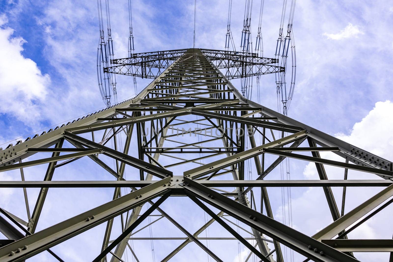 High voltage tower as steel electricity pylon with many wires against the sky, Germany