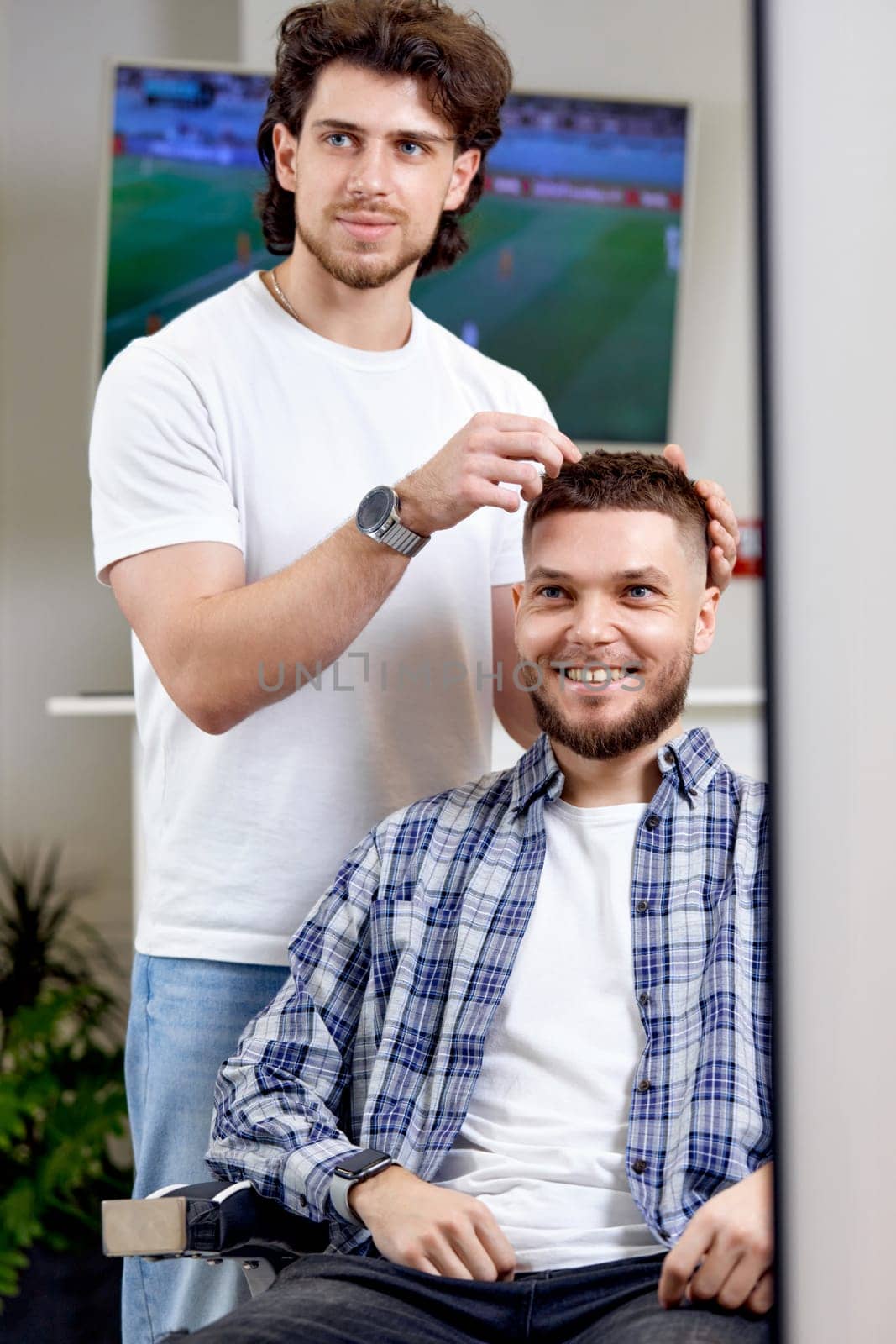 Barber and satisfied bearded man in front of the mirror in barber shop