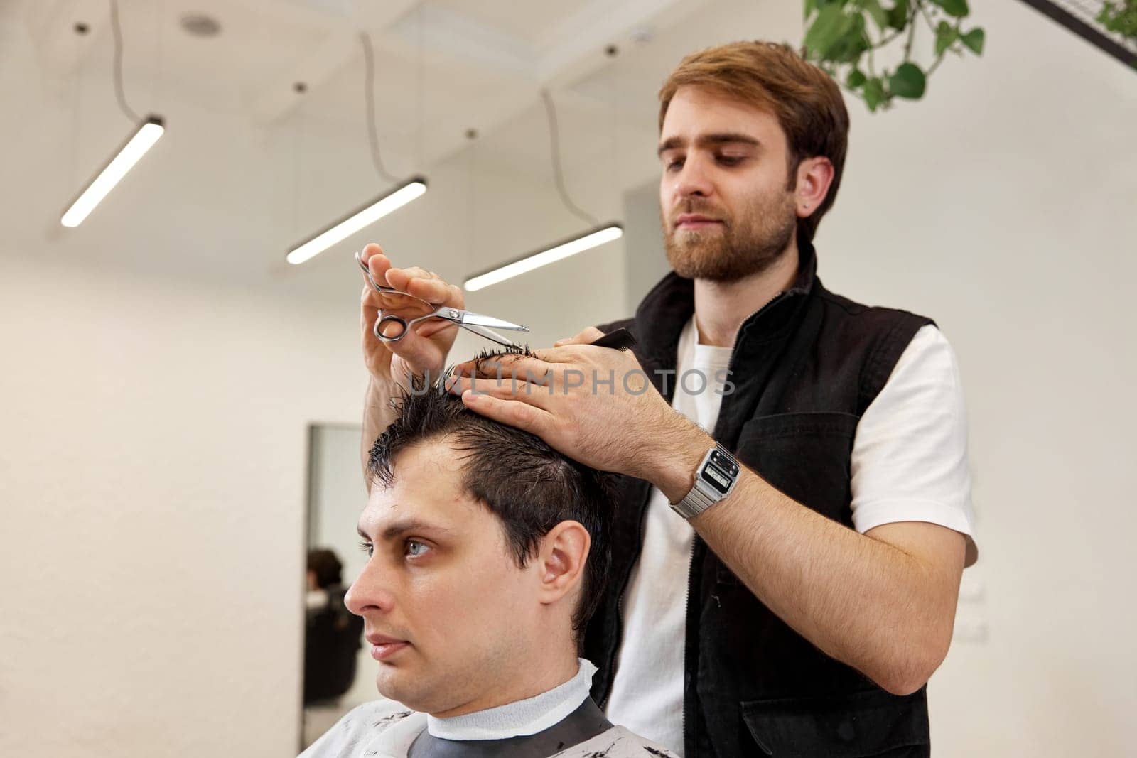 hairdresser does haircut for caucasian bearded man by erstudio