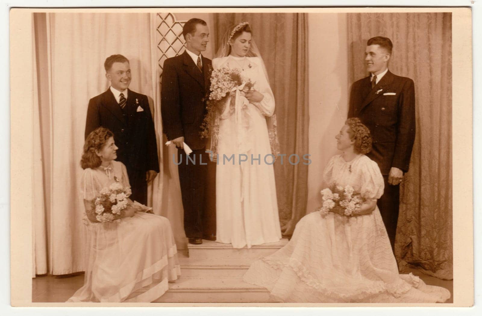 Vintage photo shows newlyweds and bridesmaids. Retro black and white photography with sepia effect. by roman_nerud