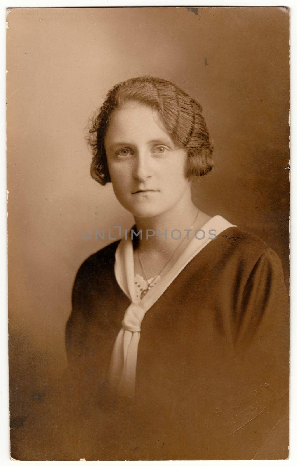 GERMANY - CIRCA 1930s: Vintage photo shows woman - portrait. Retro black and white studio photography with sepia effect.