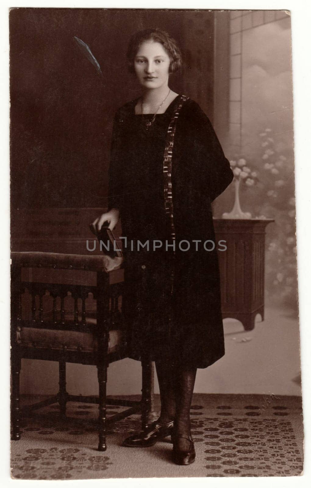 GERMANY - CIRCA 1930s: Vintage photo shows woman in a photography studio. Retro black and white studio photography with sepia effect.