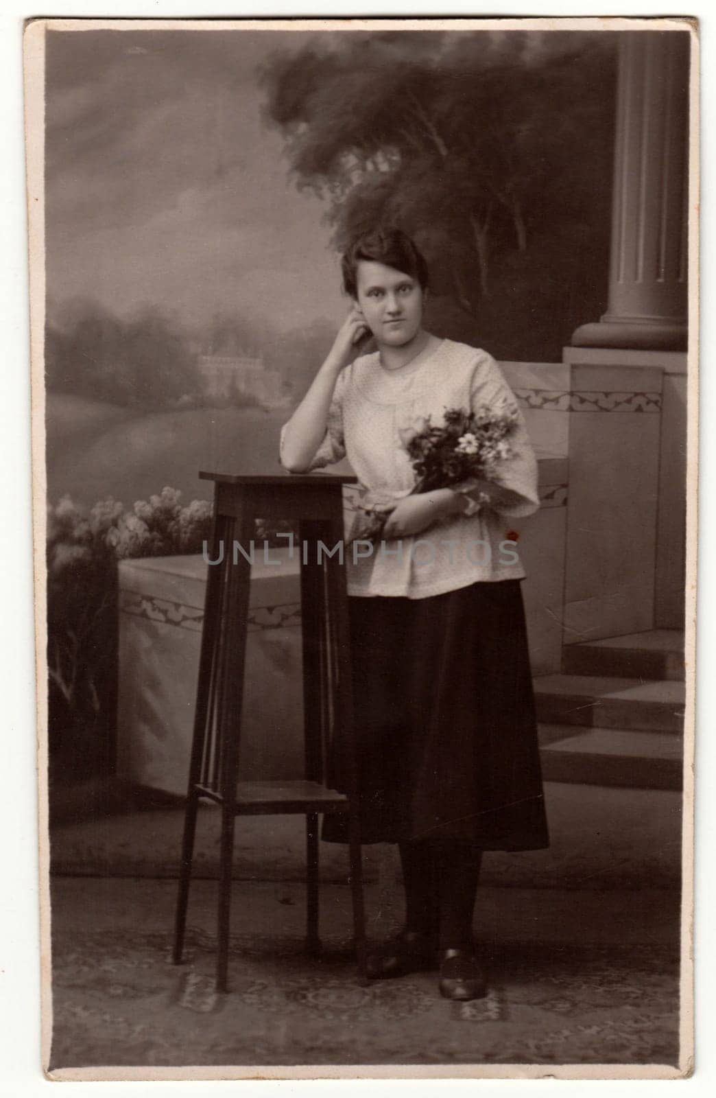 GERMANY - CIRCA 1930s: Vintage photo shows woman in a photography studio. Retro black and white studio photography with sepia effect.