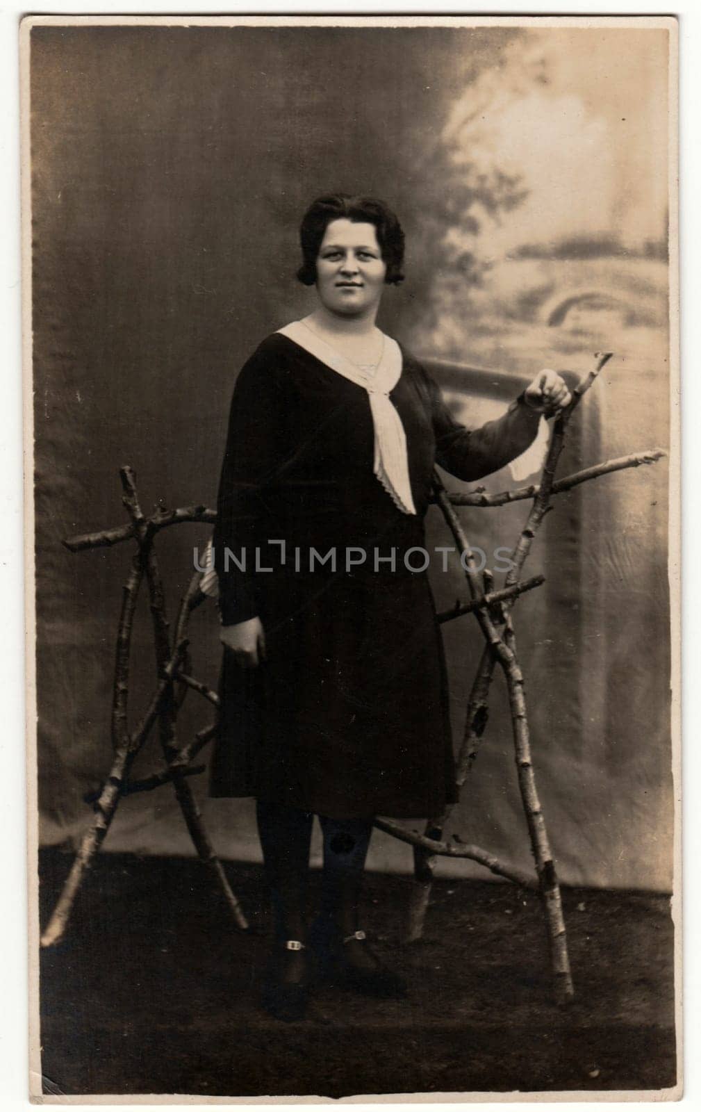 GERMANY - CIRCA 1930s: Vintage photo shows woman in a photography studio. Retro black and white studio photography with sepia effect.