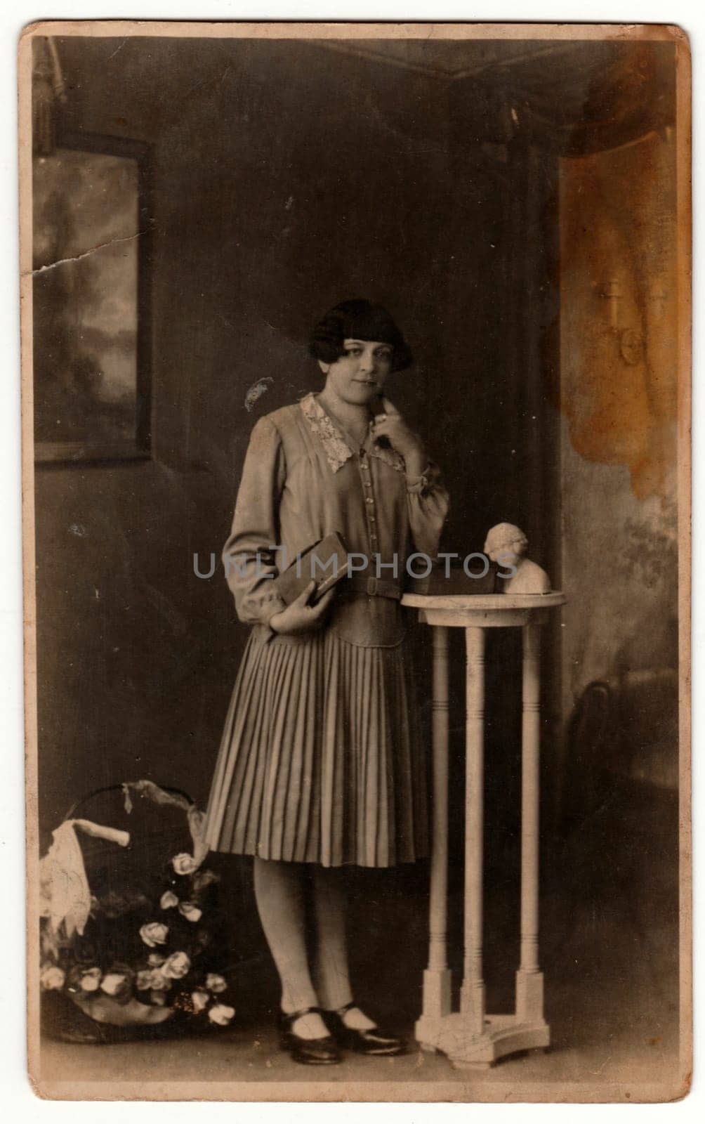 GERMANY - CIRCA 1930s: Vintage photo shows woman in a photography studio. Retro black and white studio photography with sepia effect.