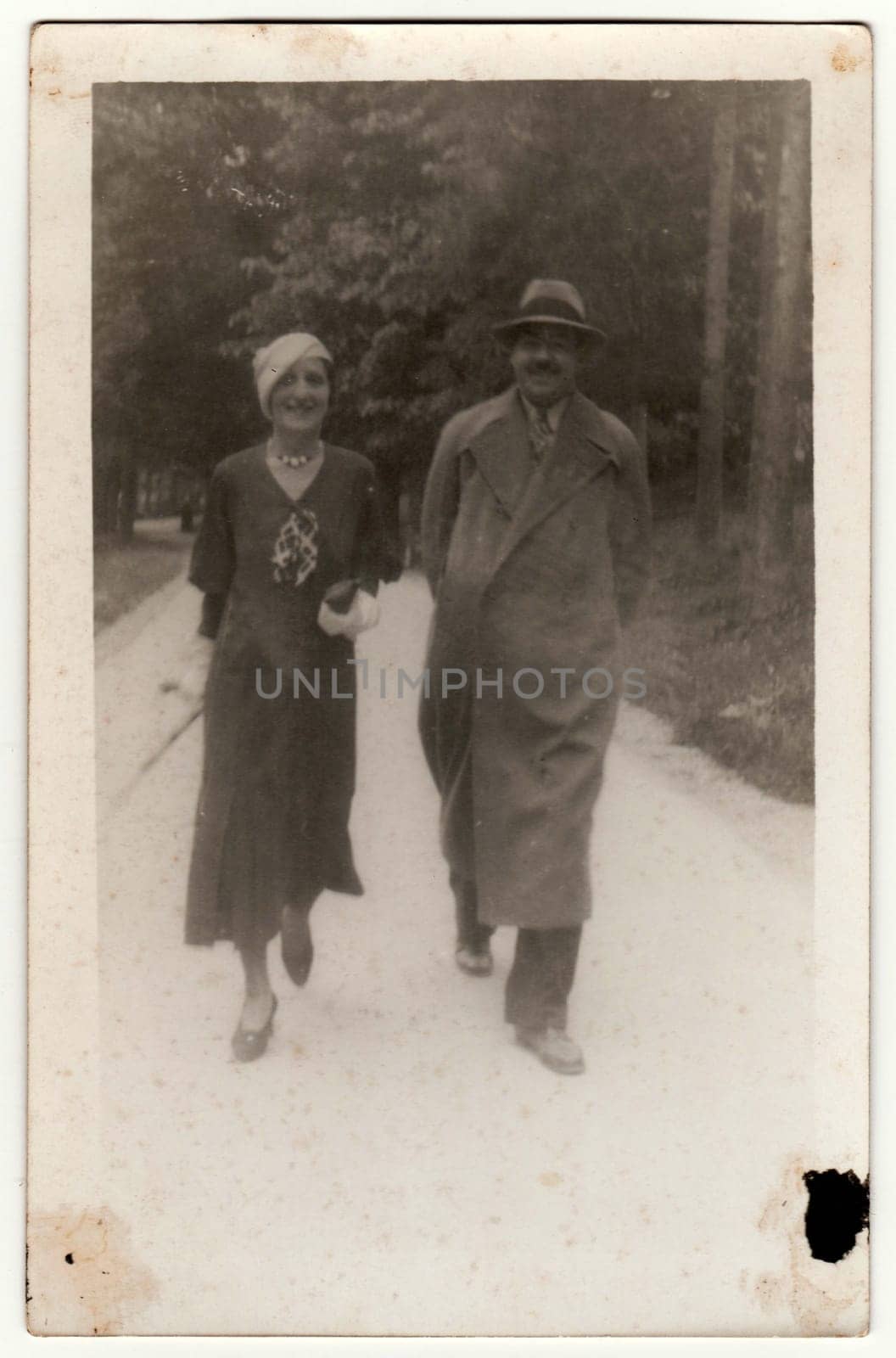 Vintage photo shows woman and man go for a walk. Original retro black and white photography taken from photo album. No postprocess by roman_nerud