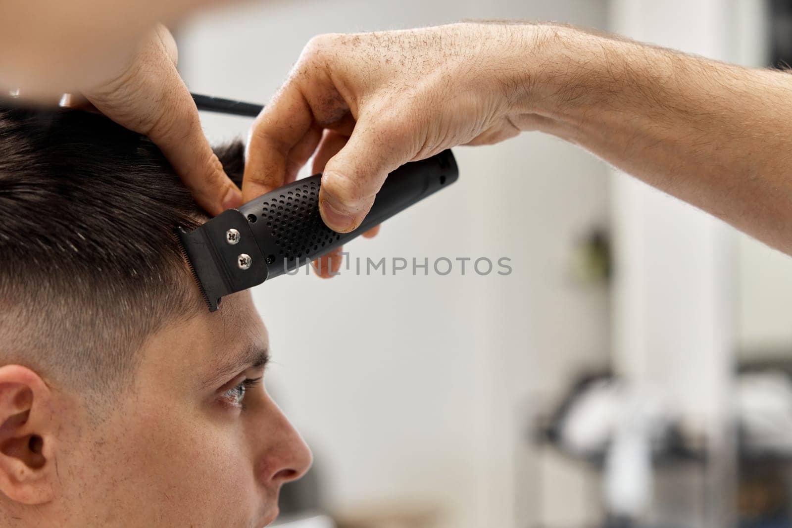 Barber shaving caucasian man in barber shop. close-up