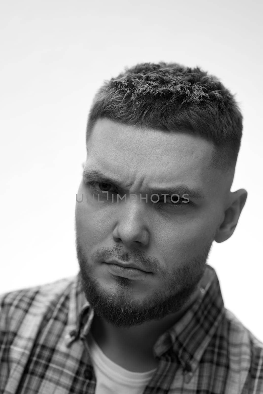 young bearded man looking at camera on white background