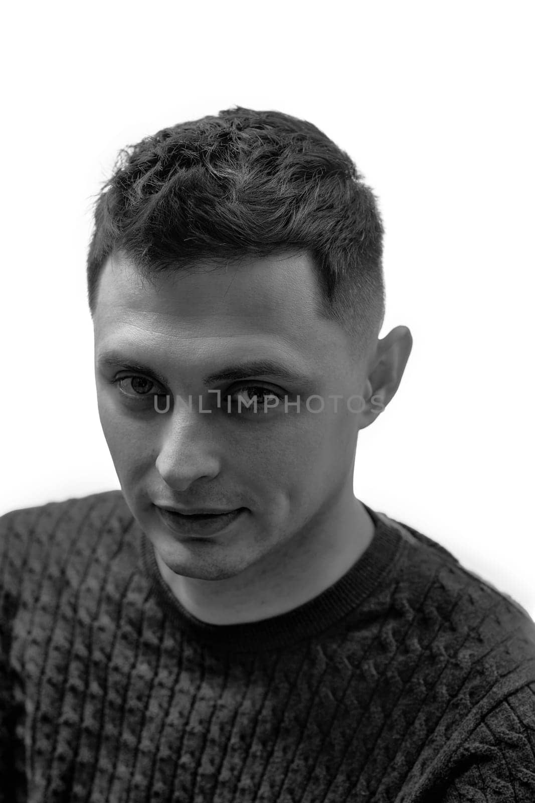 young man with stylish hair and beard looking at camera on white background