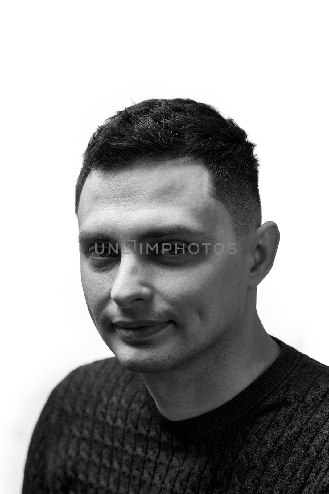 young man with stylish hair and beard looking at camera on white background
