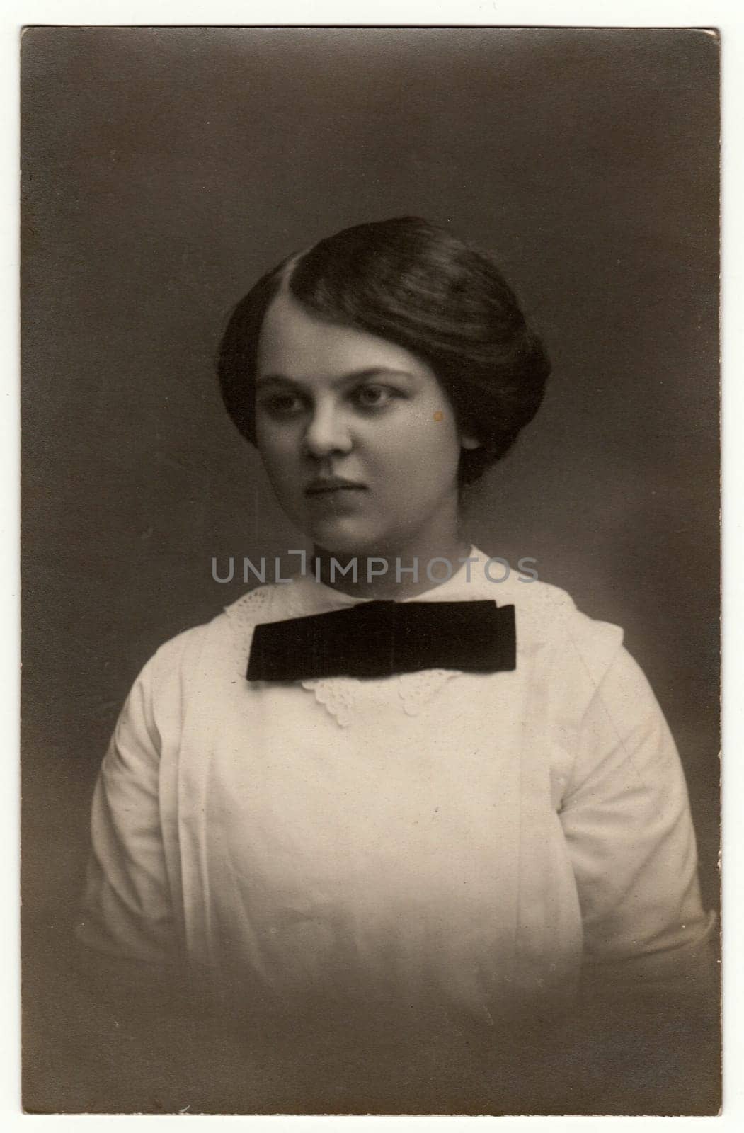 GERMANY - CIRCA 1930s: Vintage photo shows woman - portrait in a photography studio. Woman with Edwardian hairstyle. Retro black and white studio photography with sepia effect.