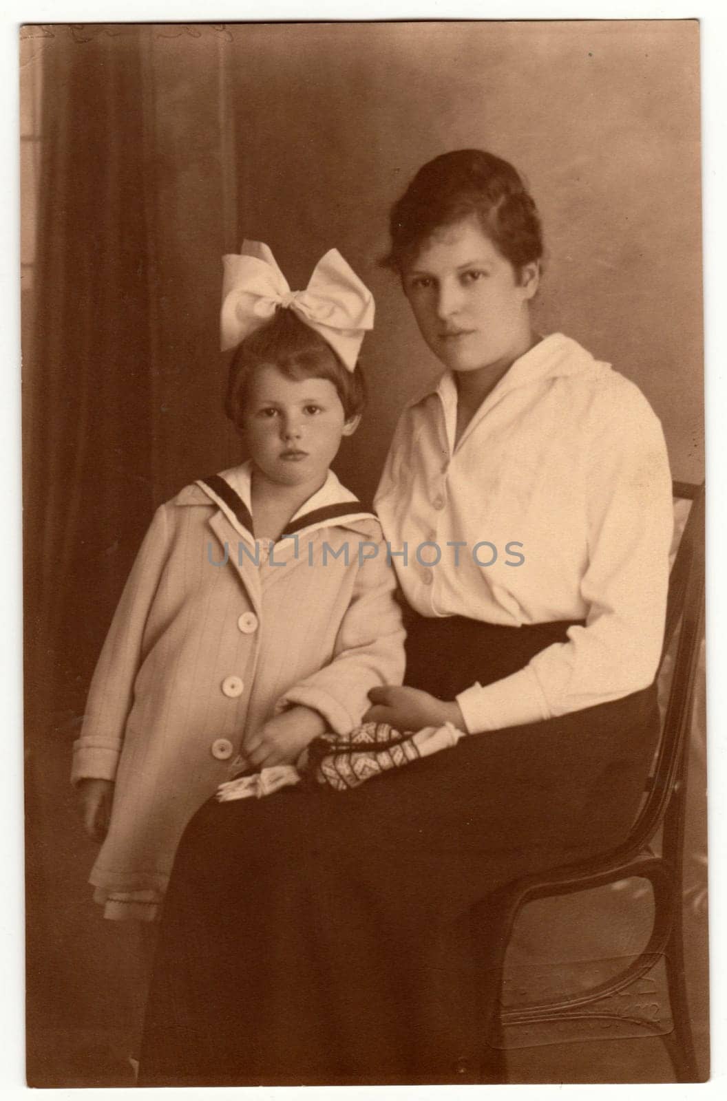 THE CZECHOSLOVAK REPUBLIC - 1919: Vintage photo shows woman with her small daughter. Retro black and white studio phortography. Circa 1920s.