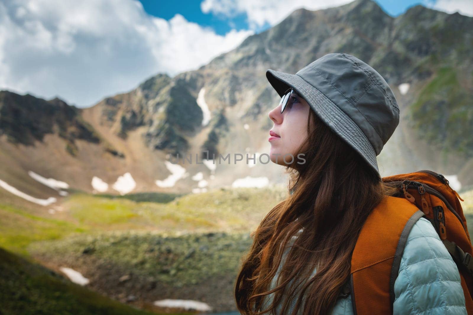 Side view portrait of a woman standing and breathing fresh air in the mountains. Profile of a female explorer breathing fresh air against by yanik88