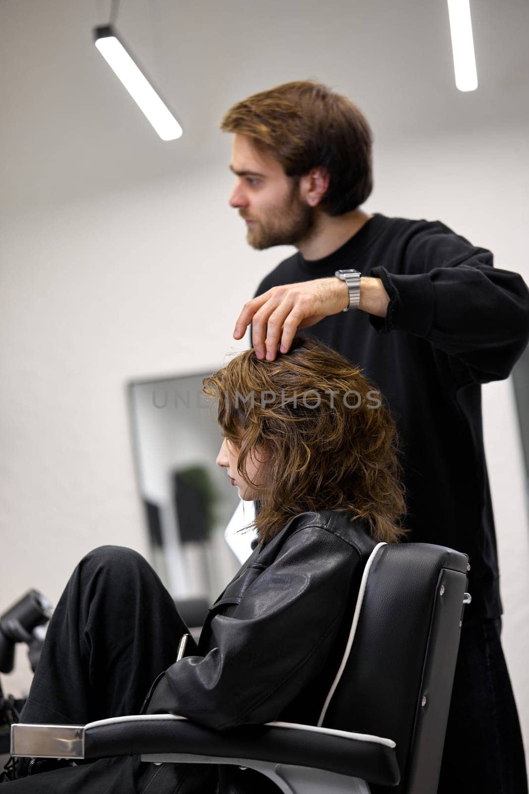 Beautiful young woman in modern hair salon. hairdresser checking hairstyle by erstudio