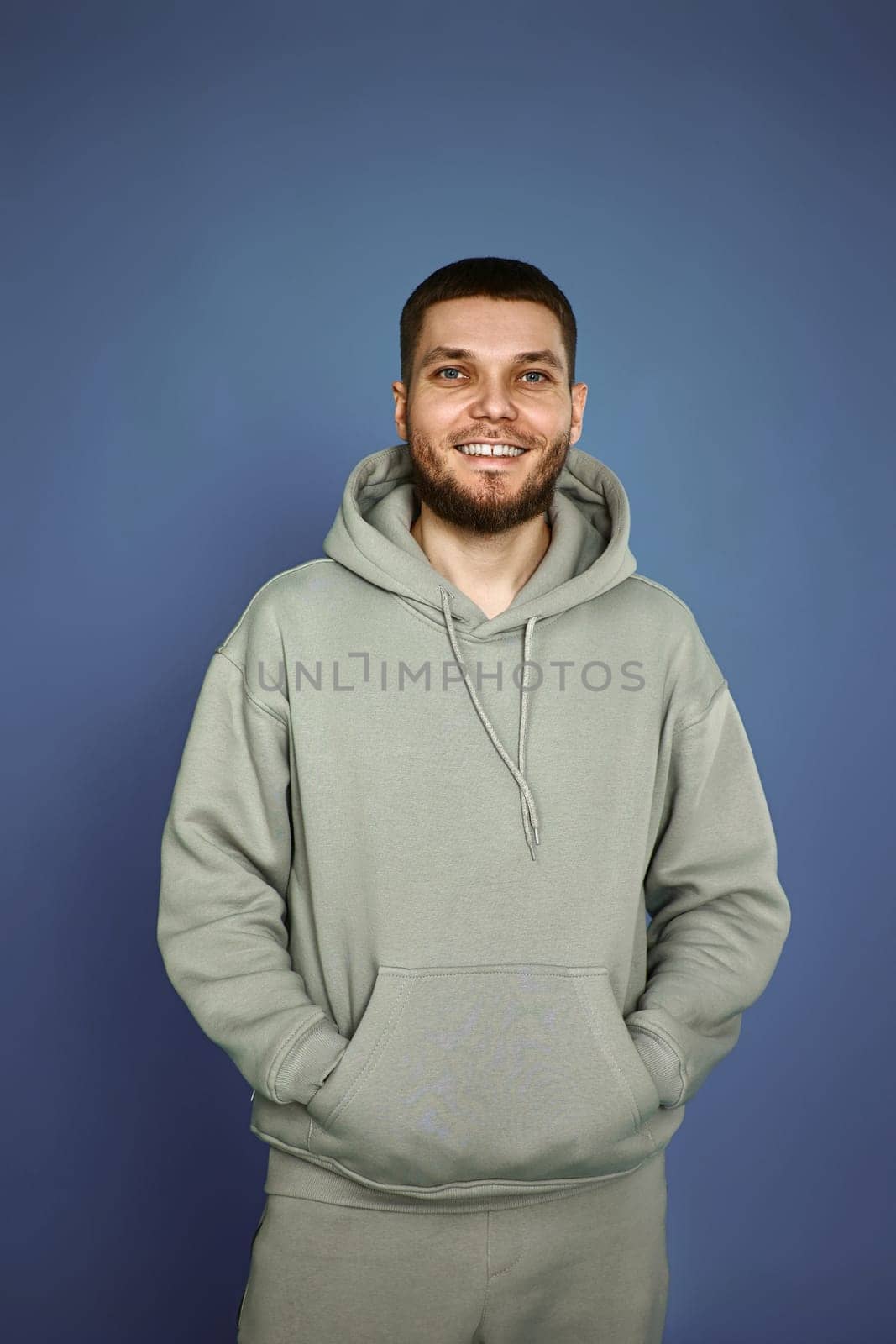 handsome bearded man in sweatshirt on gray background.