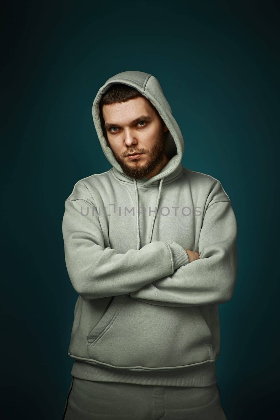 handsome bearded man in sweatshirt looking at the camera on gray background.