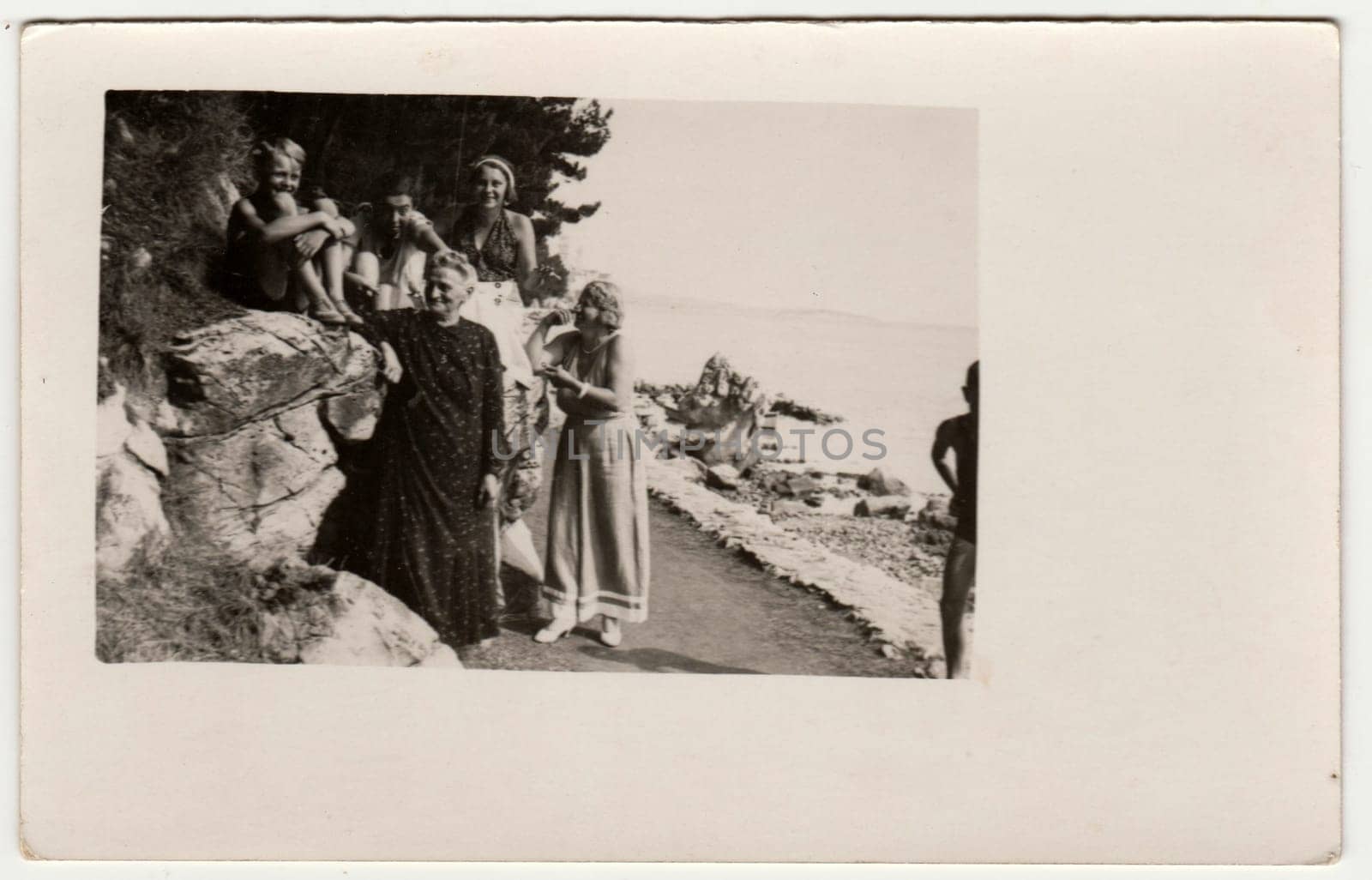 ITALY - CIRCA 1930: Vintage photo shows people on the vacation - holiday. They stand on the seashore. Retro black and white photography. Circa 1930s.