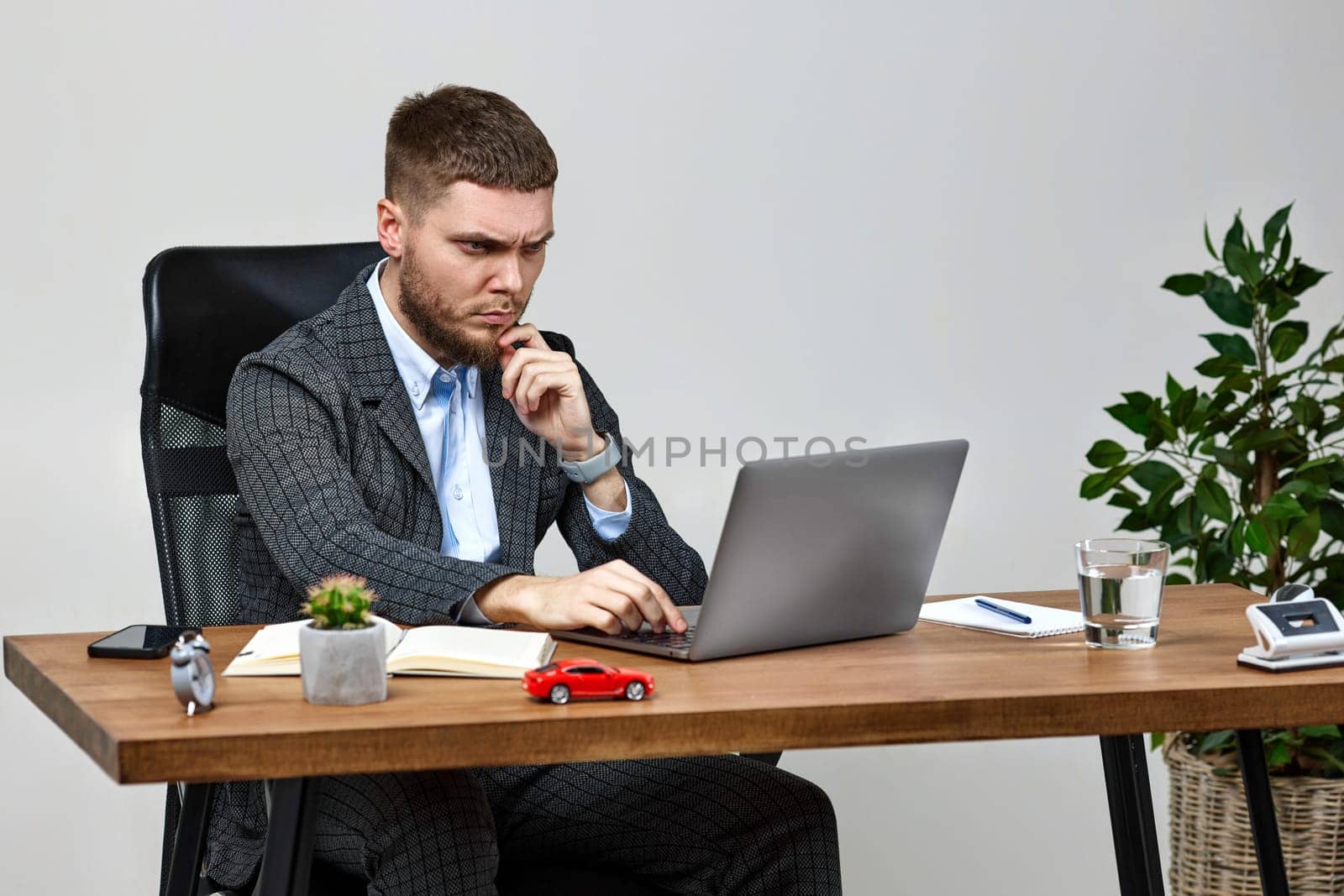 young man sitting on chair at table and resting, using laptop