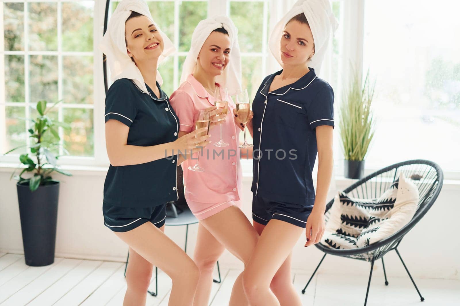 Cheerful young women in pajamas having fun indoors at daytime together by Standret