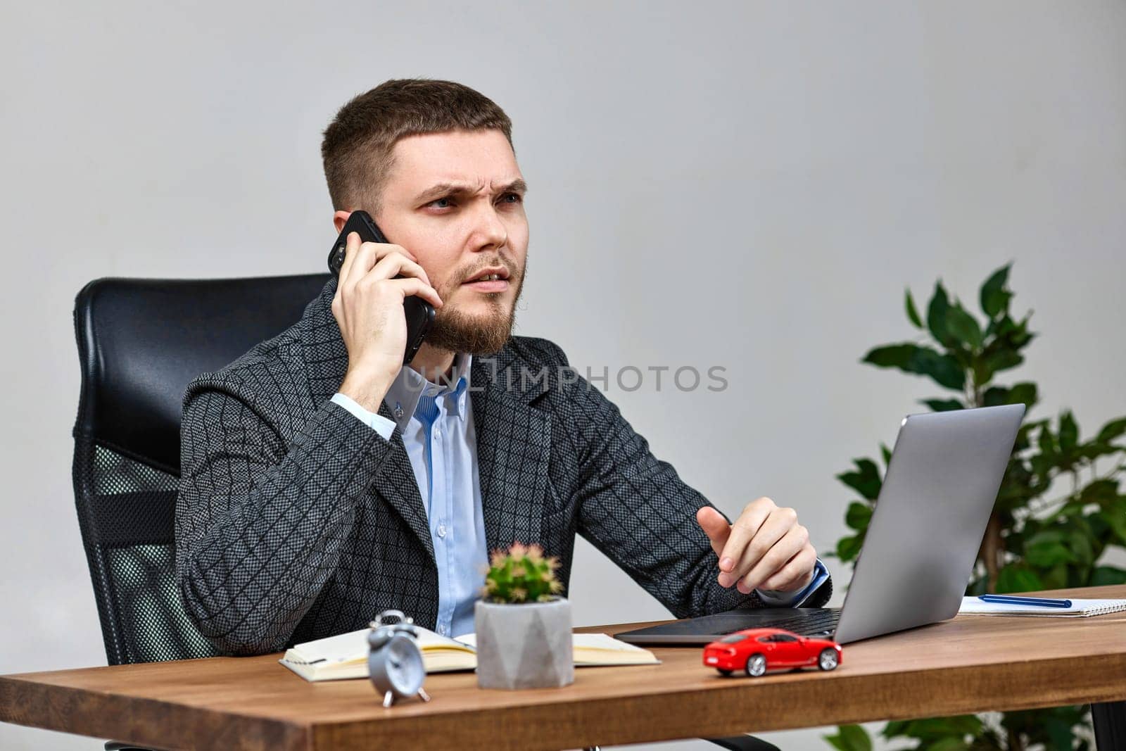 businessman working with laptop and having phone conversation with client