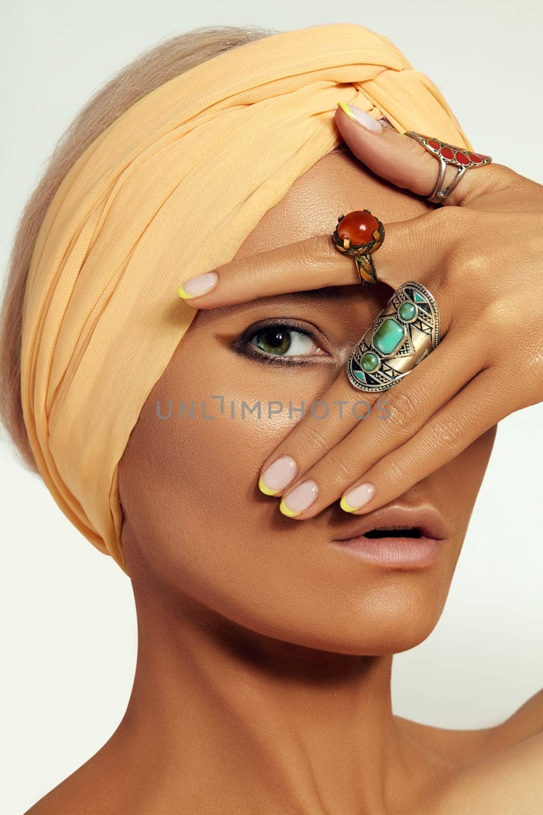 Beauty young Woman wearing Turban. Oriental Boho Style with Bohemian Accessories, Beautiful Rings, Fashion Make-up. Tanned Smooth Skin, Dark Arabian Makeup, Luxury Jewelry Rings and Perfect Manicure