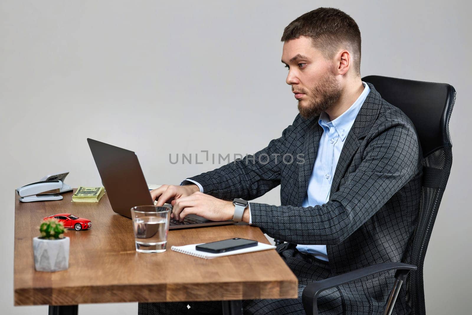 calm bearded businessman typing on computer keyboard, sending emails to business partners