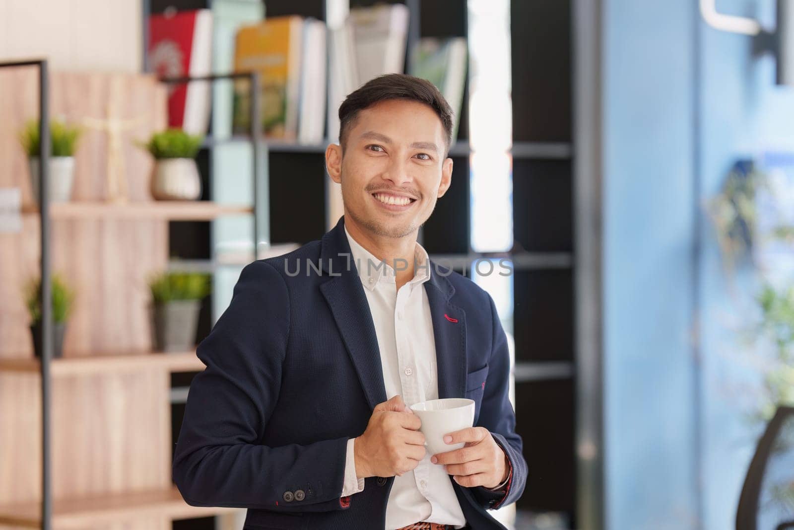 Smiling Asian Banker makes financial report and studies annual figures, analyzes profits. Accountant checks status of financial.