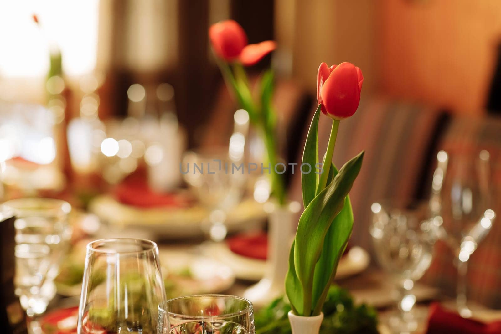 festive set table for the holiday with tulips flowers. High quality photo by Andriimedvediuk