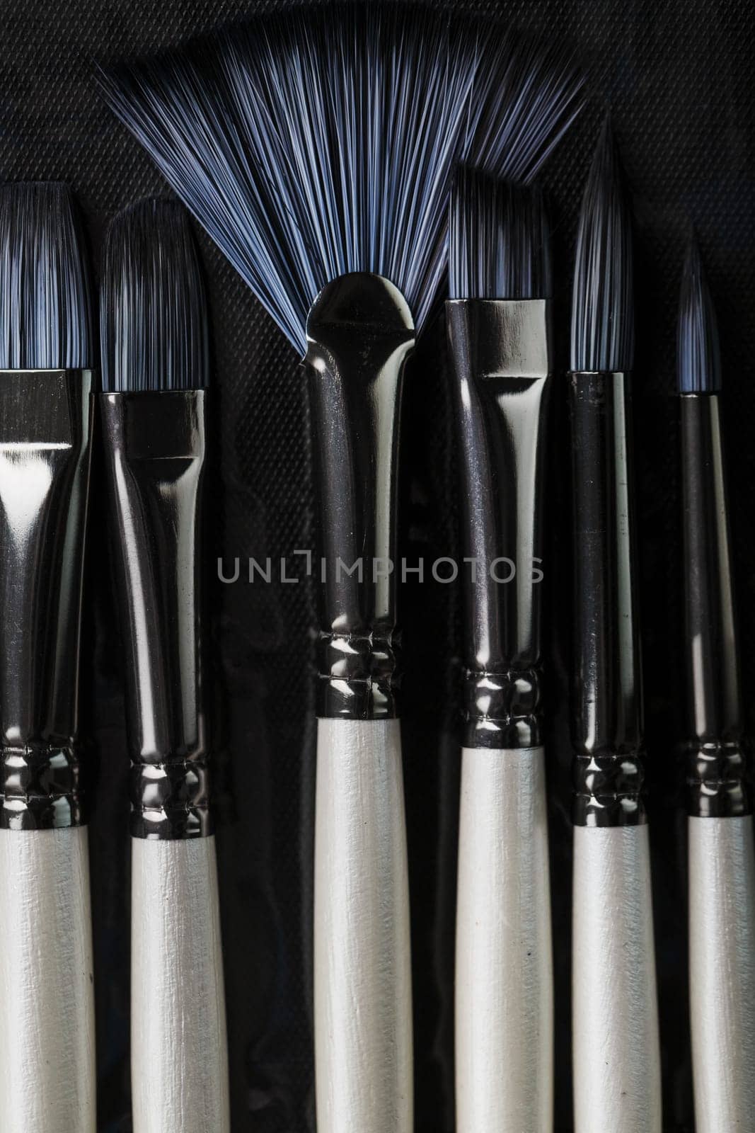 A set of oil brushes and palette knife isolated on a black background, Close-up