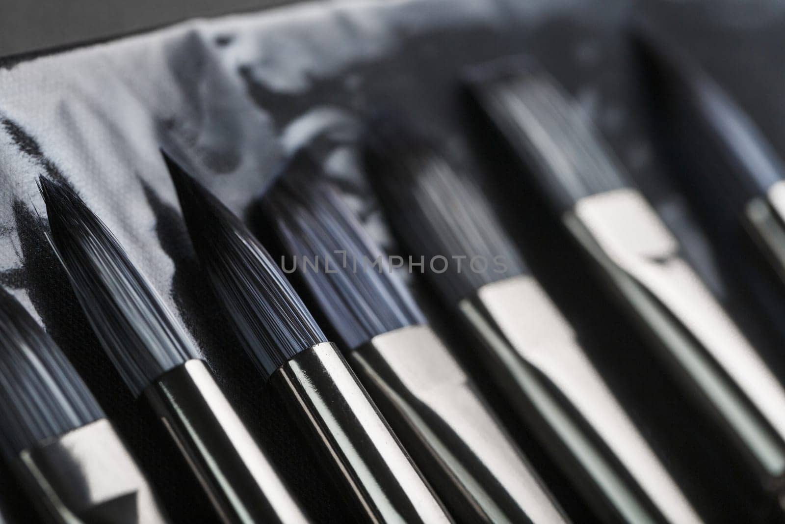 Paint tubes, brushes for painting and palette knifes on old wooden background