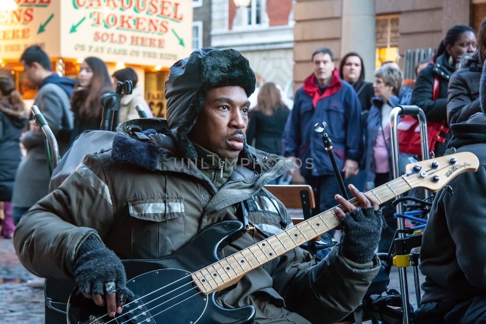 London, United Kingdom - November 25th, 2006: Unknown busker plays bass guitar and signs at Covent Garden. Street performers are performing often in this area, as it's popular tourist spot.