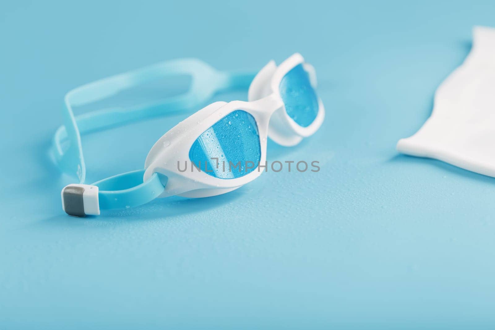 Swimming goggles in a white frame with a blue filter on a blue background