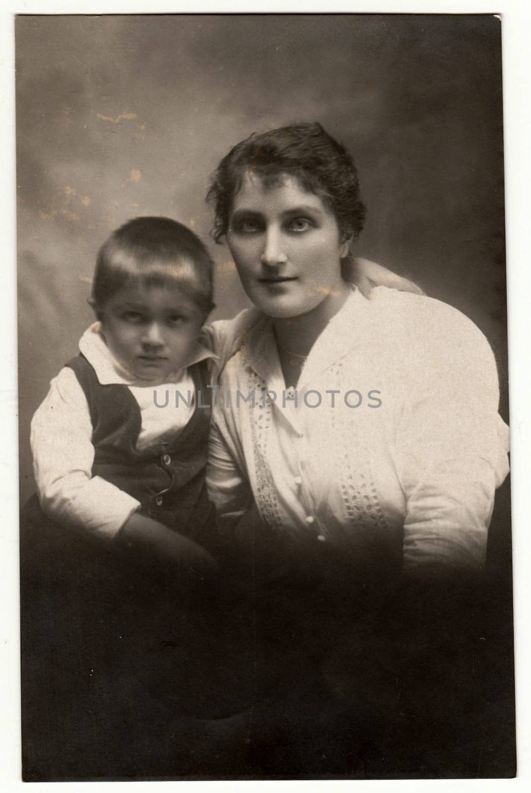 THE CZECHOSLOVAK REPUBLIC - CIRCA 1920s: Vintage photo shows a small boy with mother. Retro black and white studio photography. Circa 1920s.