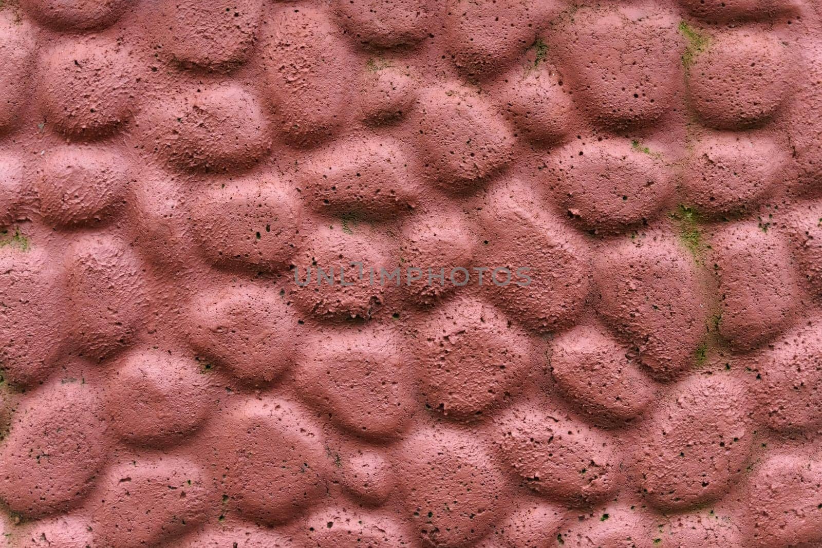 The texture of the concrete wall is made to look like stone and painted red-brown.
