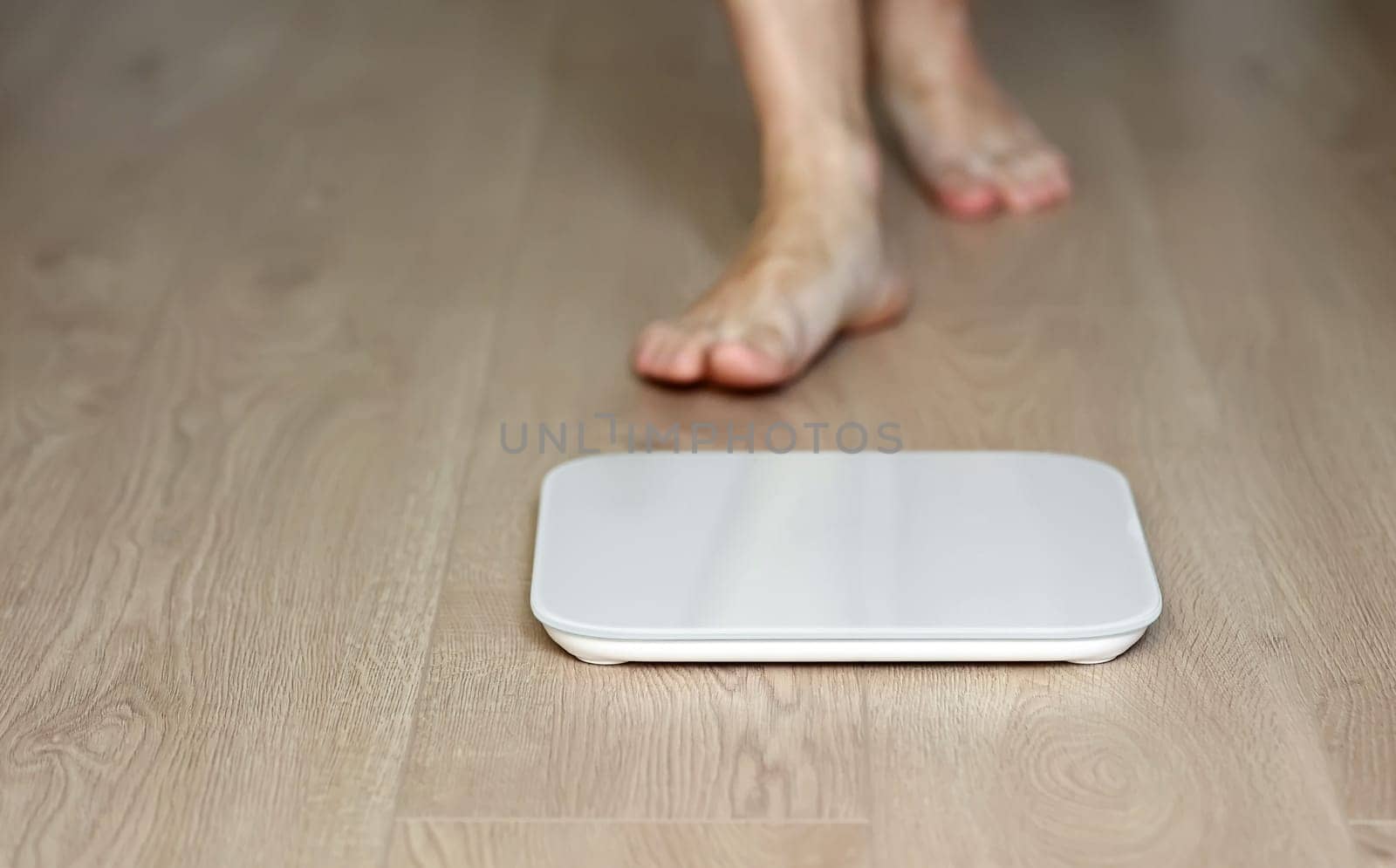 Man walking on scales measure weight. male wal checking BMI weight loss. human barefoot measuring body fat overweight. Guy legs step on bathroom scale.