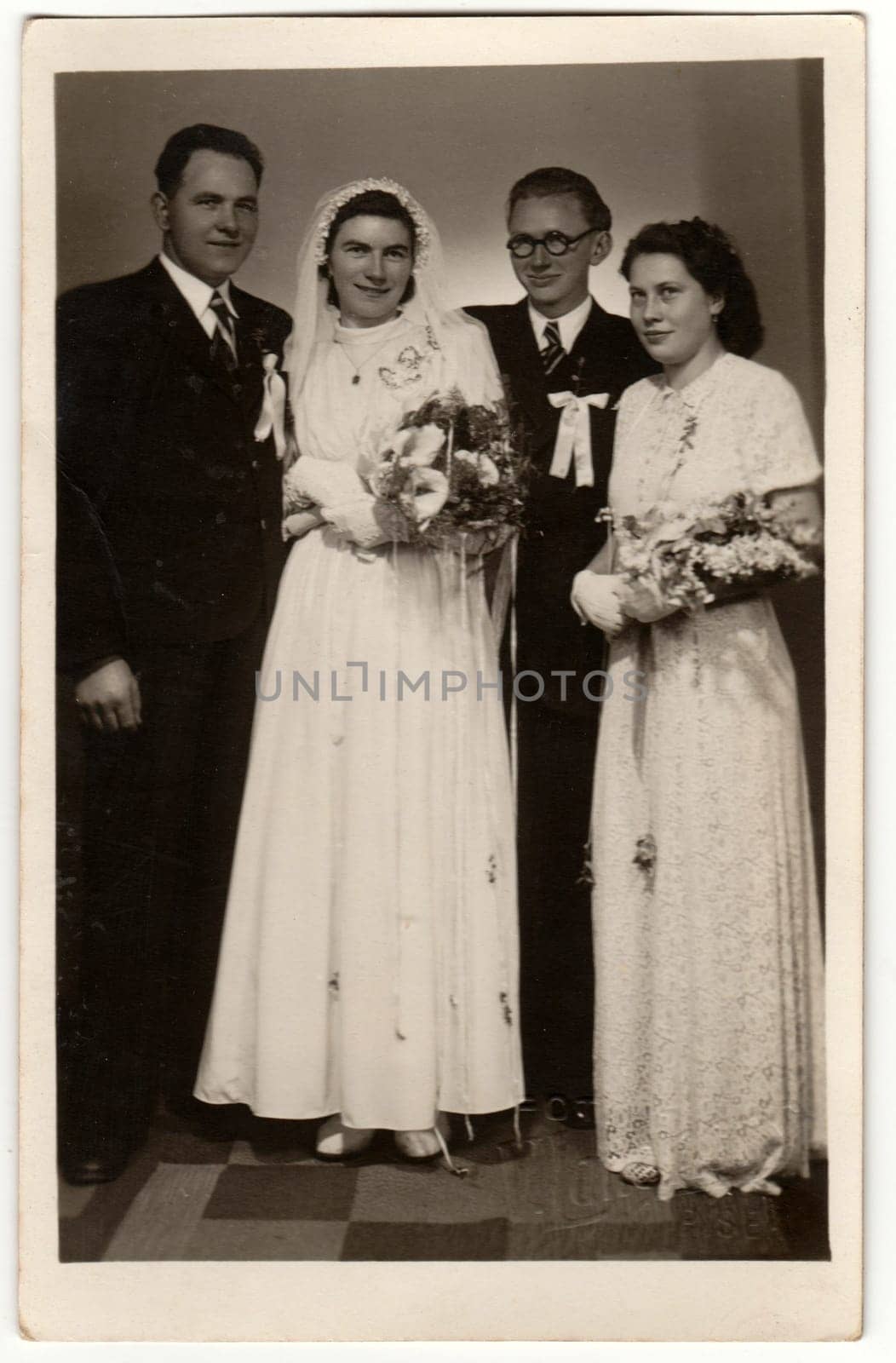 Vintage photo shows newlyweds and bridesman with bridesmaid. Retro black and white photography. Circa 1920s. by roman_nerud