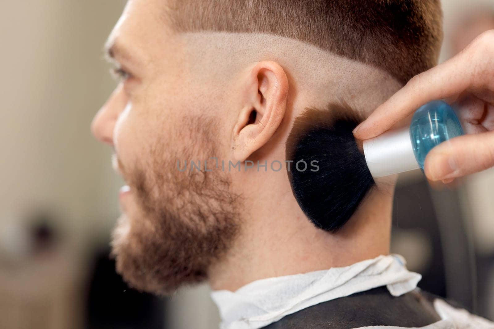 barber holding brush for talco in barber shop. close-up