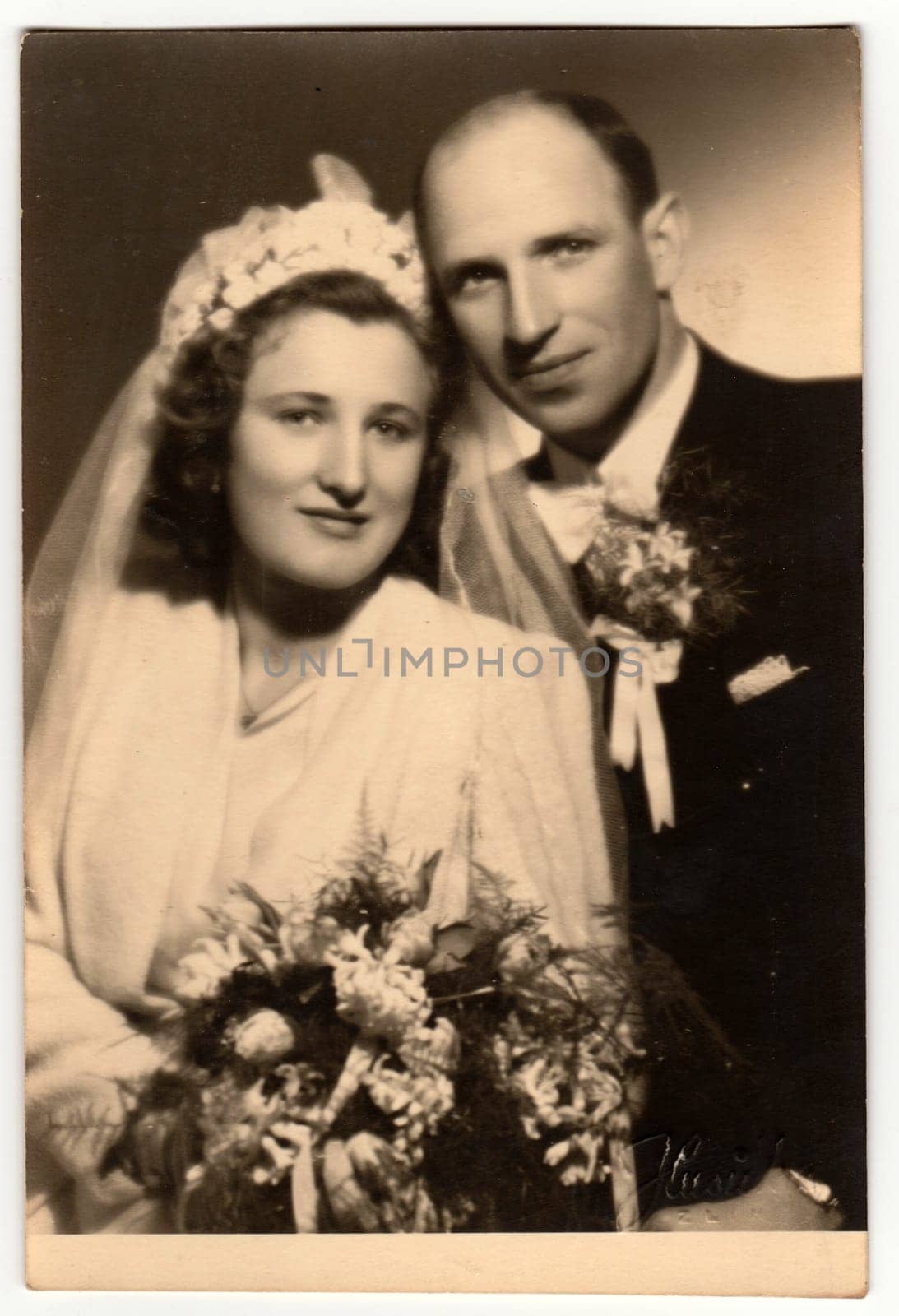 Vintage photo shows newlyweds pose after wedding ceremony. Retro black and white studio photography. Circa 1940s. by roman_nerud