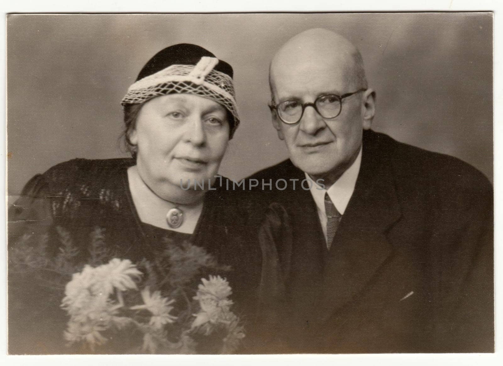 KLATOVY, THE CZECHOSLOVAK SOCIALIST REPUBLIC - NOVEMBER 10, 1949: Vintage photo shows a married couple - silver wedding - anniversary. Retro black and white studio photography.