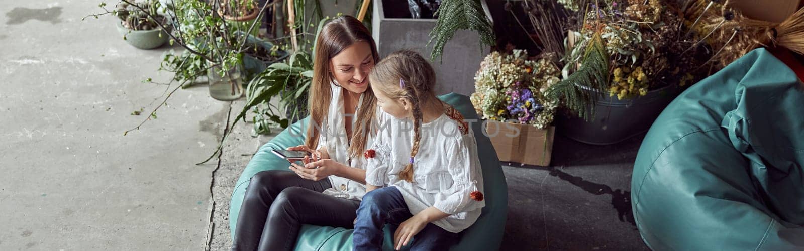 Happy caucasian mother with young beautiful cheerful daughter are having time together