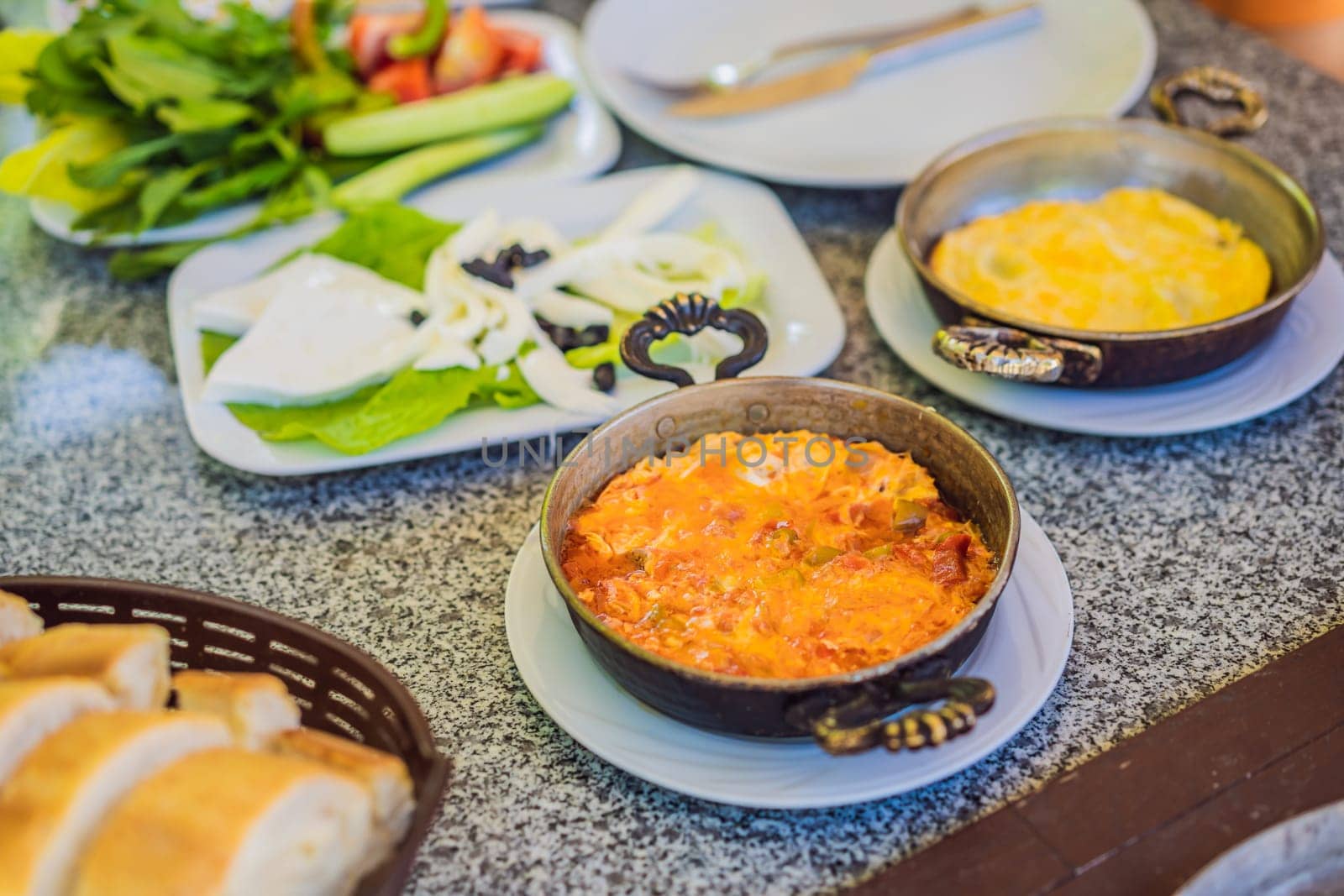 Turkish breakfast table. Pastries, vegetables, greens, olives, cheeses, fried eggs, spices, jams, honey, tea in copper pot and tulip glasses, wide composition by galitskaya