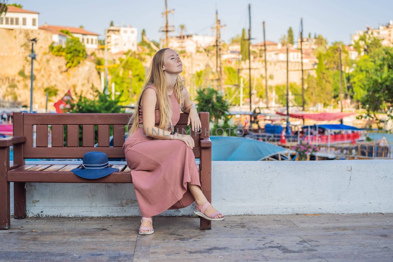 Woman tourist in Old town Kaleici in Antalya. Turkiye. Panoramic view of Antalya Old Town port, Taurus mountains and Mediterrranean Sea, Turkey.