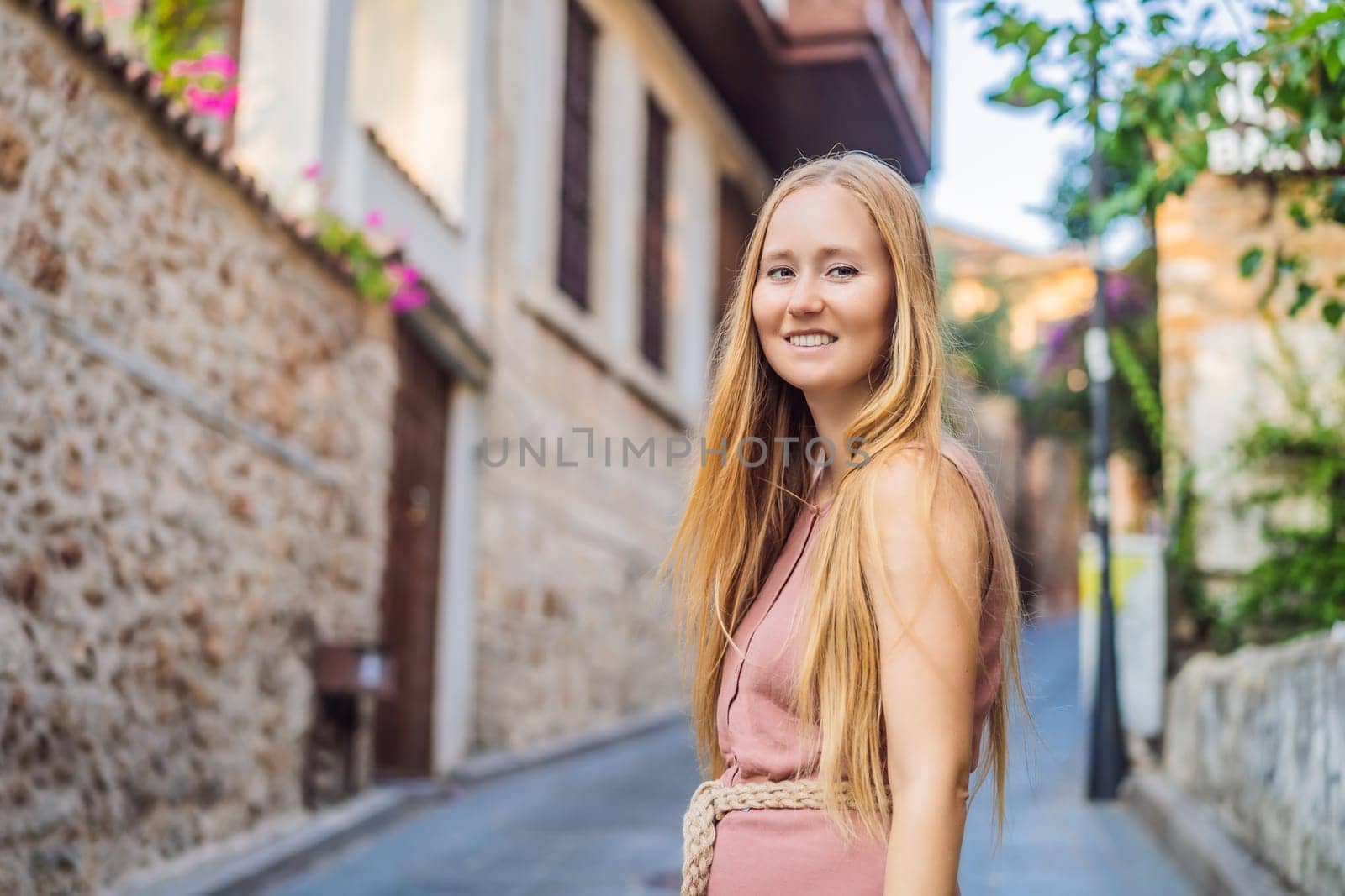 Woman tourist in Old town Kaleici in Antalya. Turkiye. Panoramic view of Antalya Old Town port, Taurus mountains and Mediterrranean Sea, Turkey.