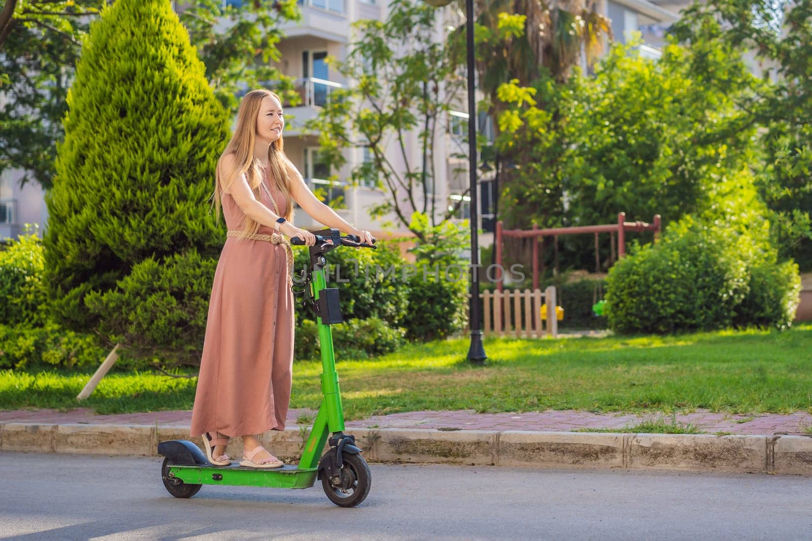 Young beautiful woman riding an electric scooter to work, modern girl, new generation, electric transport, ecology, ecological transport, sunset, electric skateboard.