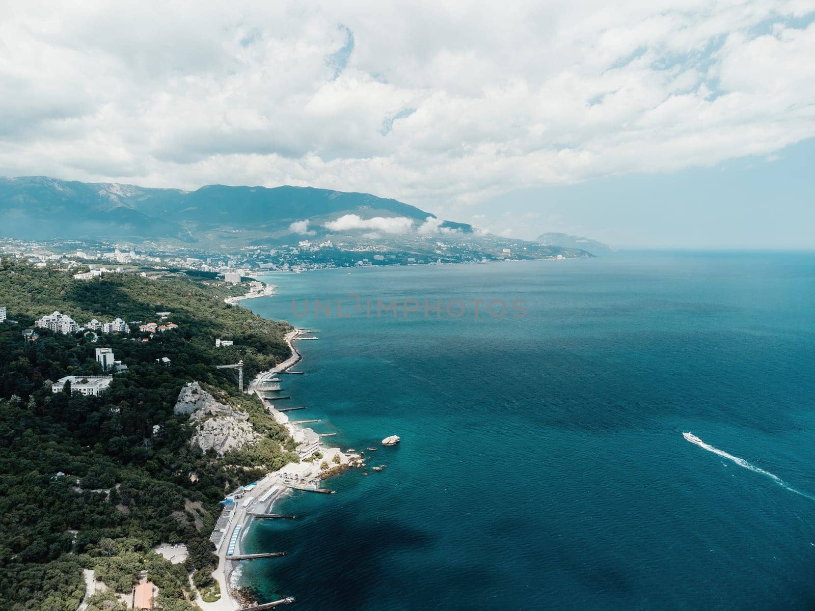 Christian church on a background of mountains. Temple of the Holy Archangel Michael in Oreanda. The southern coast of Crimea. Located on a rocky cliff and is surrounded by beautiful vegetation