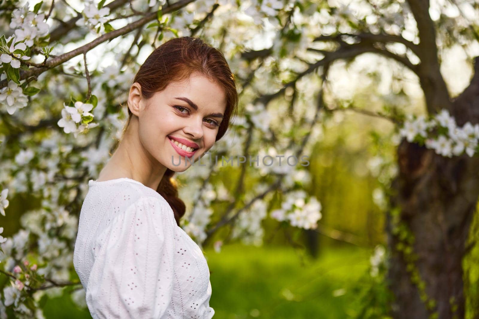 beautiful woman standing near blossoming bush. High quality photo