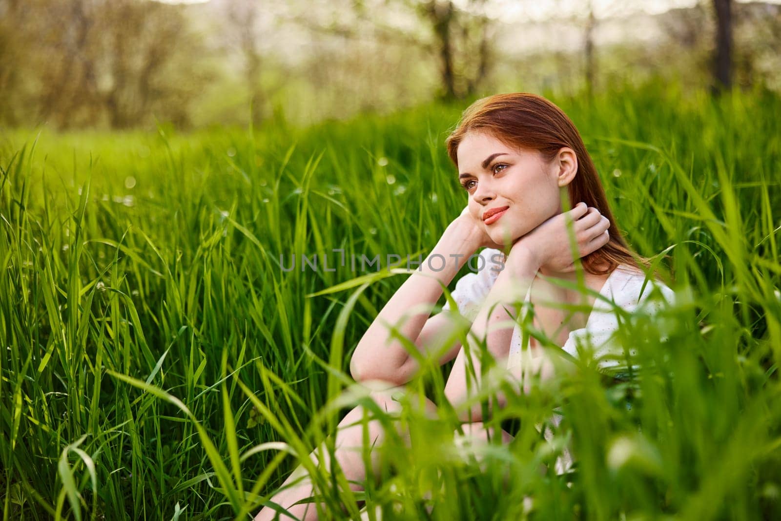 sunny summer day, a beautiful young woman lying on the grass by Vichizh