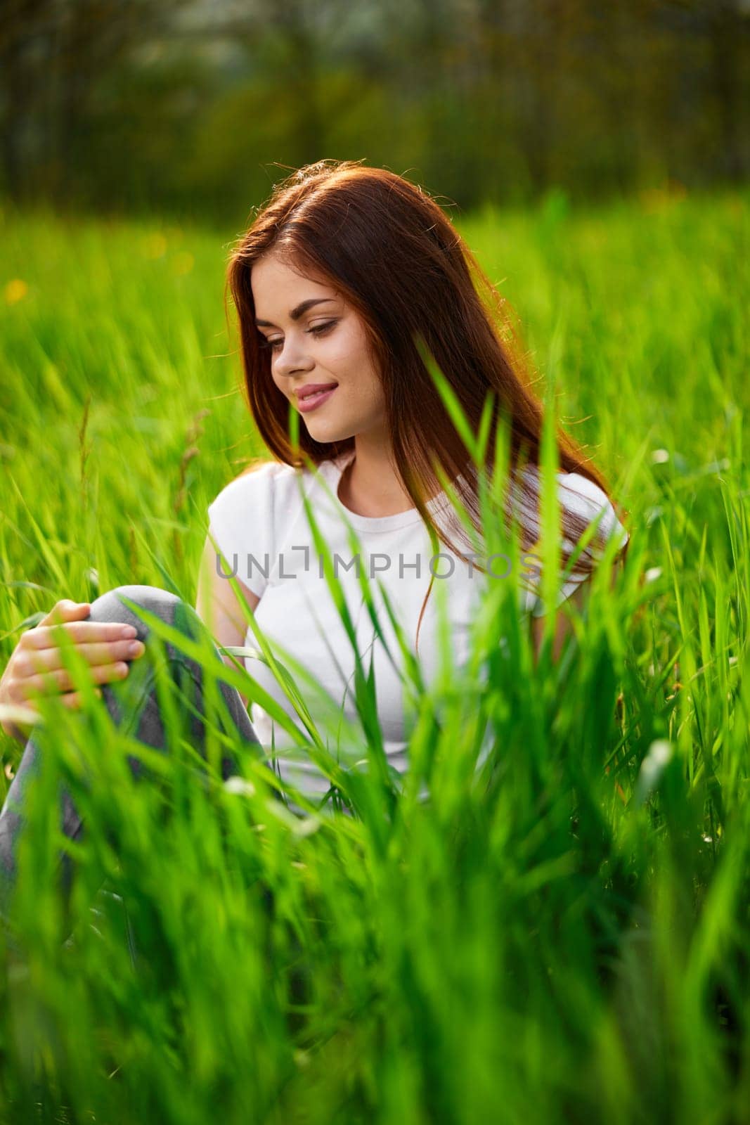 portrait of a joyful cute woman sitting in the grass. High quality photo